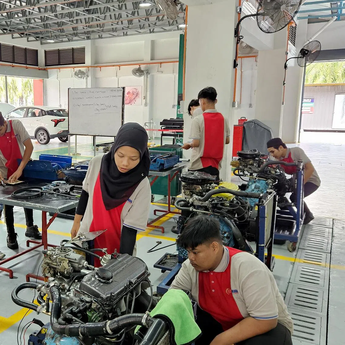 Technical and Vocational Education and Training students exploring an internal combustion engine at GiatMARA's  Bagan Datuk campus.