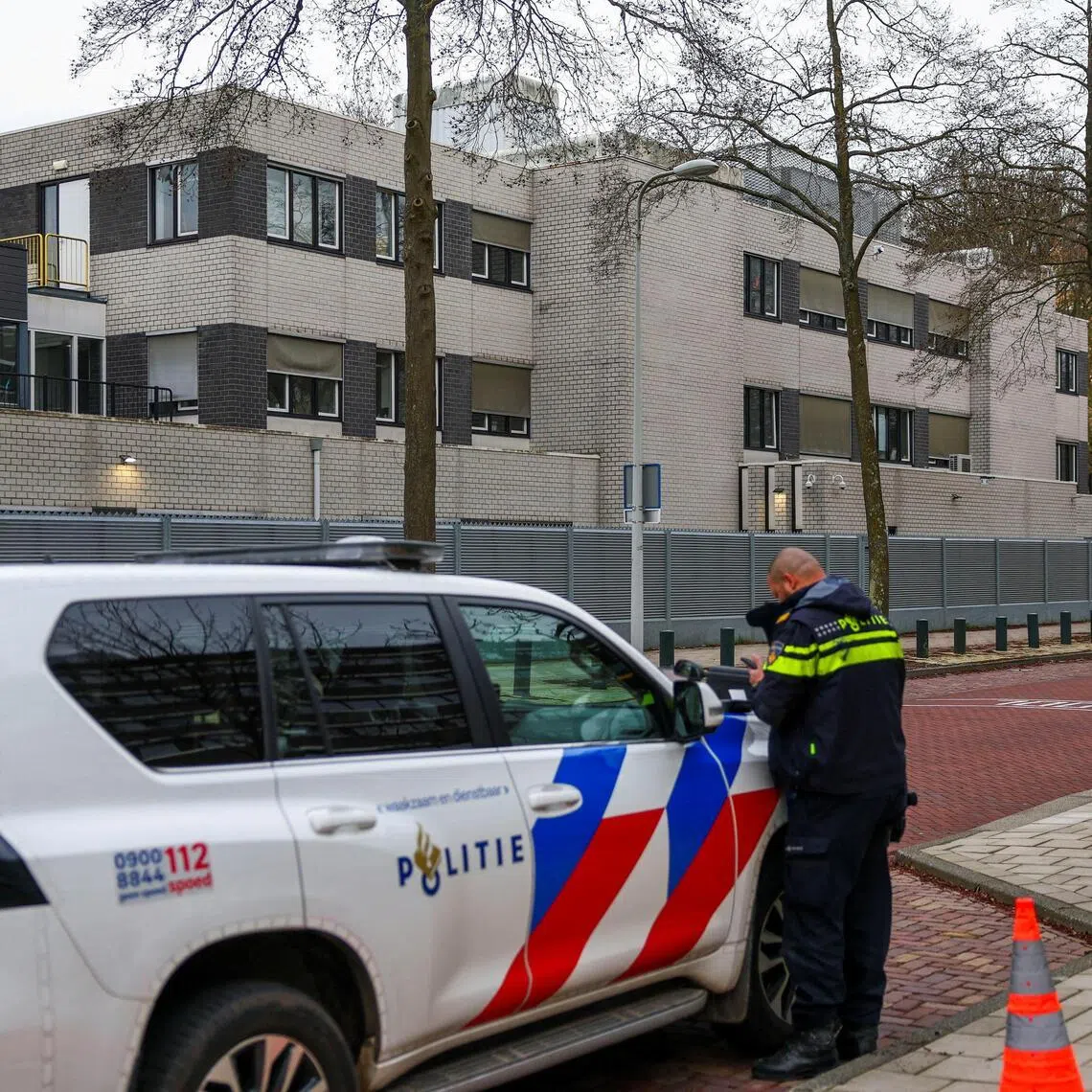 Police officers stand outside a Jewish school following an explosion that caused minor damages, in Amsterdam, Netherlands, on March 14, 2026.