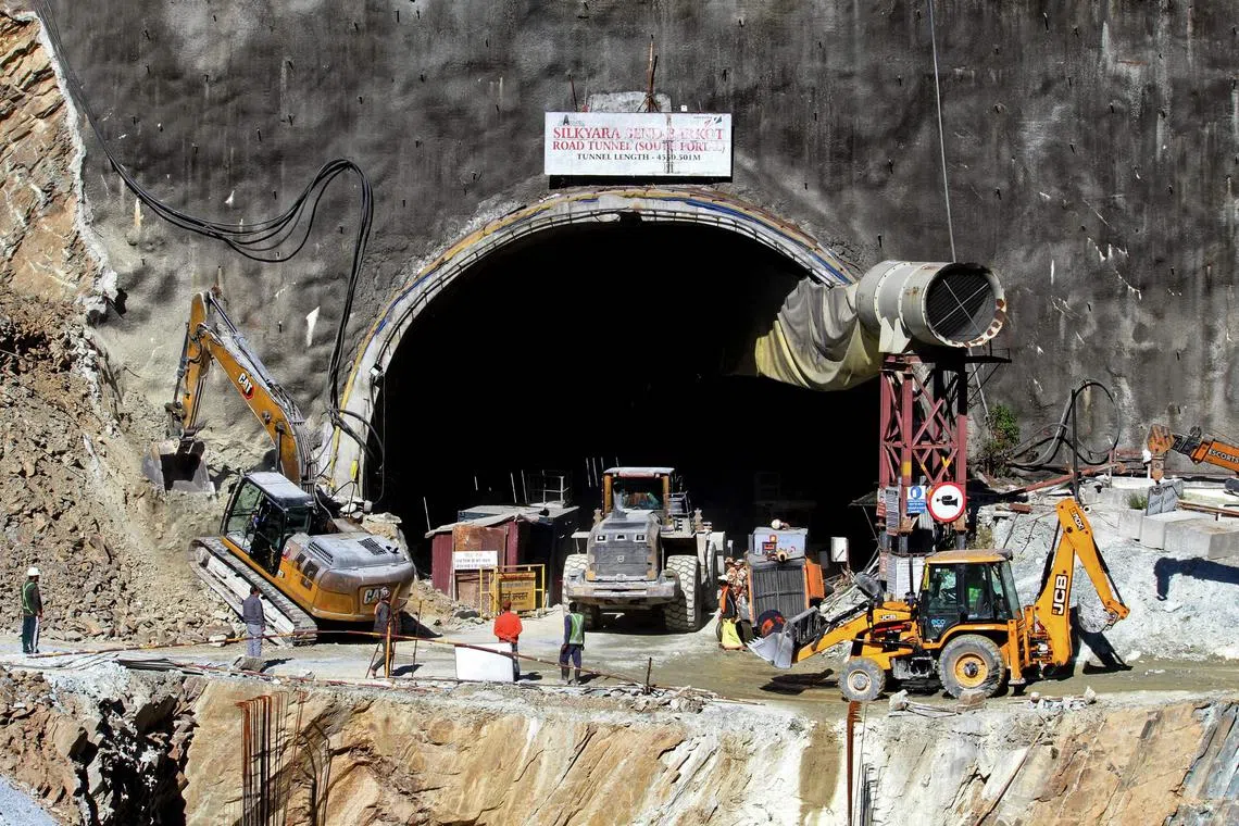 Rescue workers stand at an entrance of the under construction road tunnel, days after it collapsed in the Uttarkashi district of India's Uttarakhand state.