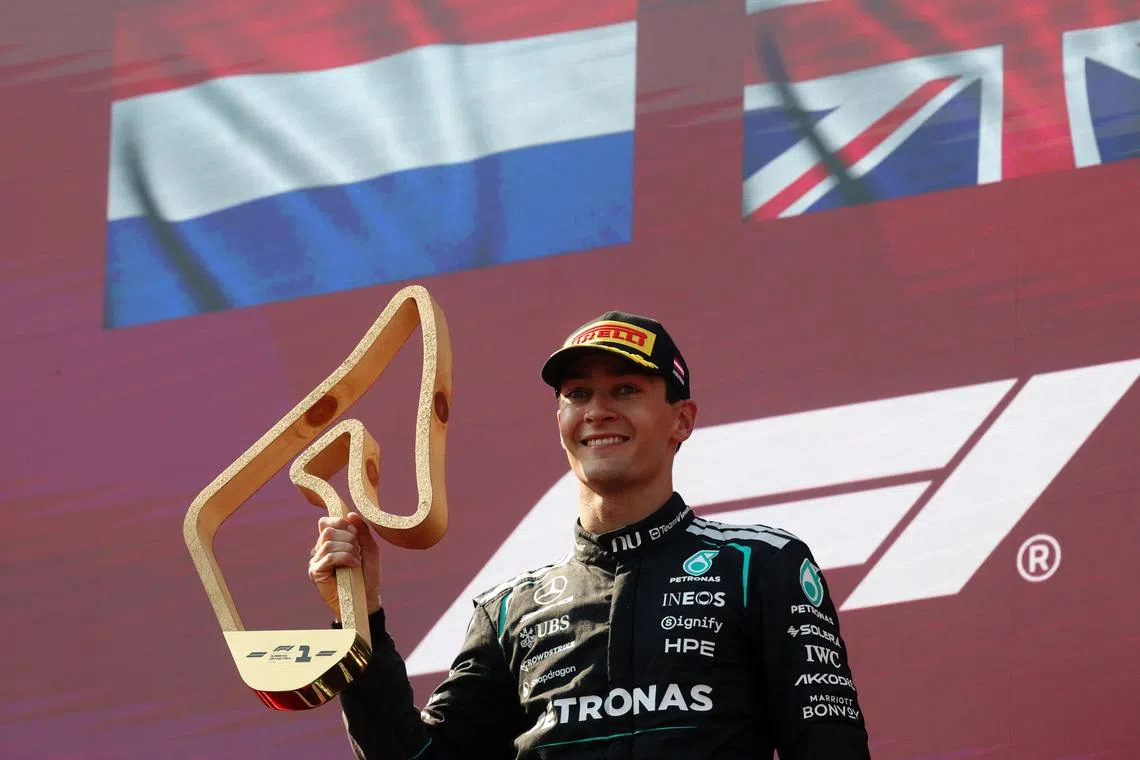 Mercedes’ George Russell celebrates with a trophy on the podium after winning the Austrian Grand Prix on June 28.
