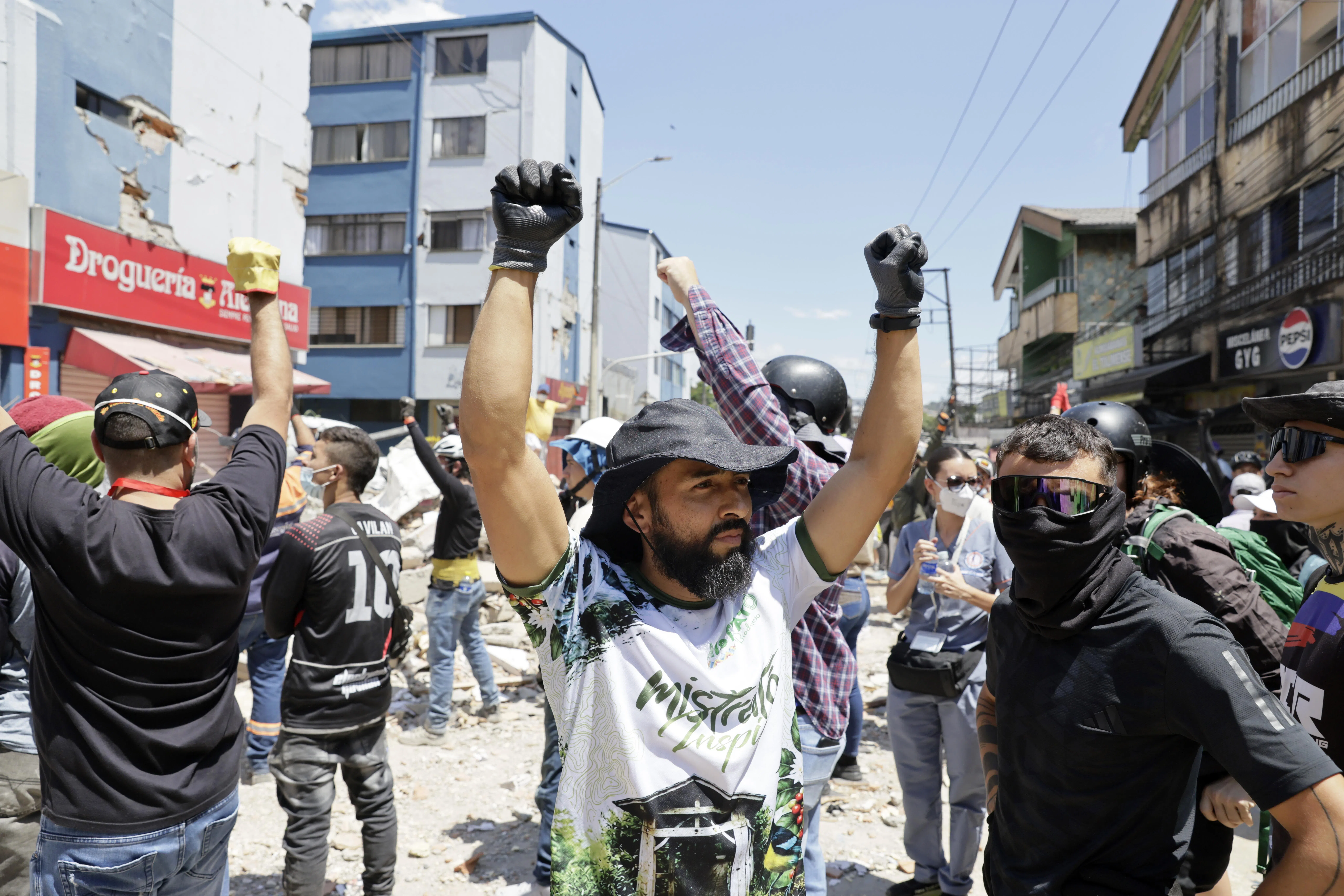 Rescuers and volunteers raising their arms to call for silence as they search for survivors in Pereira, Colombia, on Aug 11.
