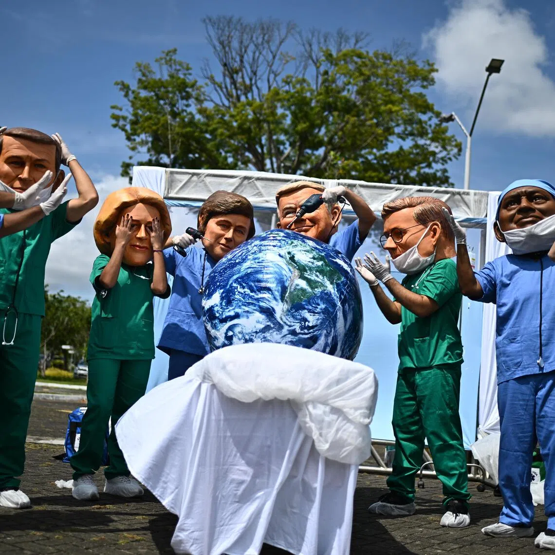 Protesters wearing masks depicting world leaders in Belem, Brazil, on Nov 20.