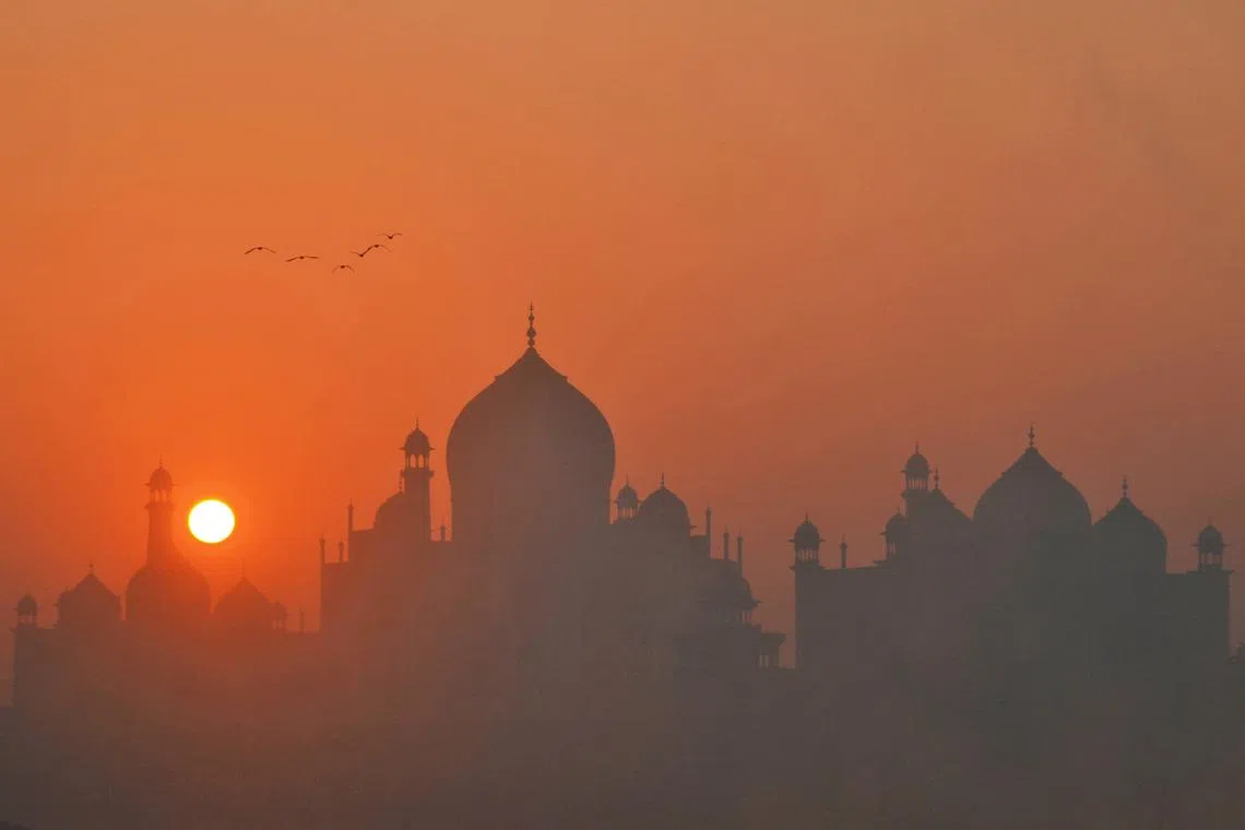 Birds fly against the backdrop of Taj Mahal on a foggy winter morning in Agra on Jan 18, 2023.