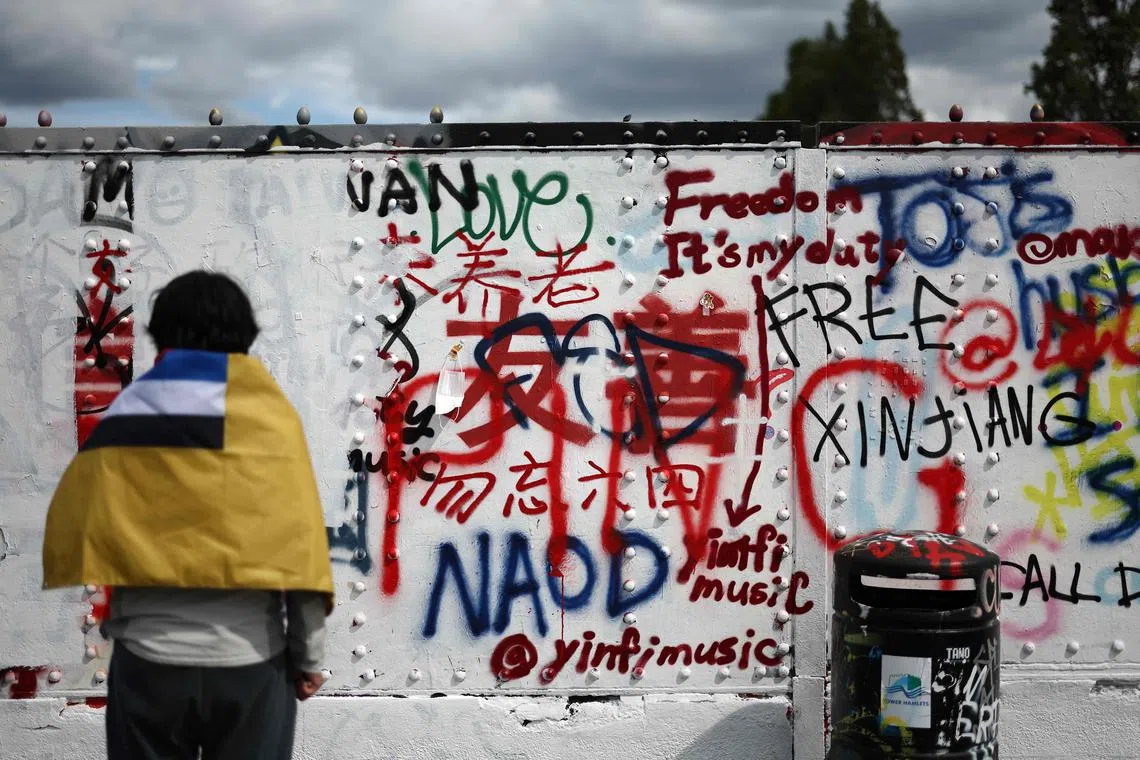 Pro- and anti-Beijing graffiti that has been written and over-written written on a white-washed wall in the Brick Lane area of east london on Aug 7.