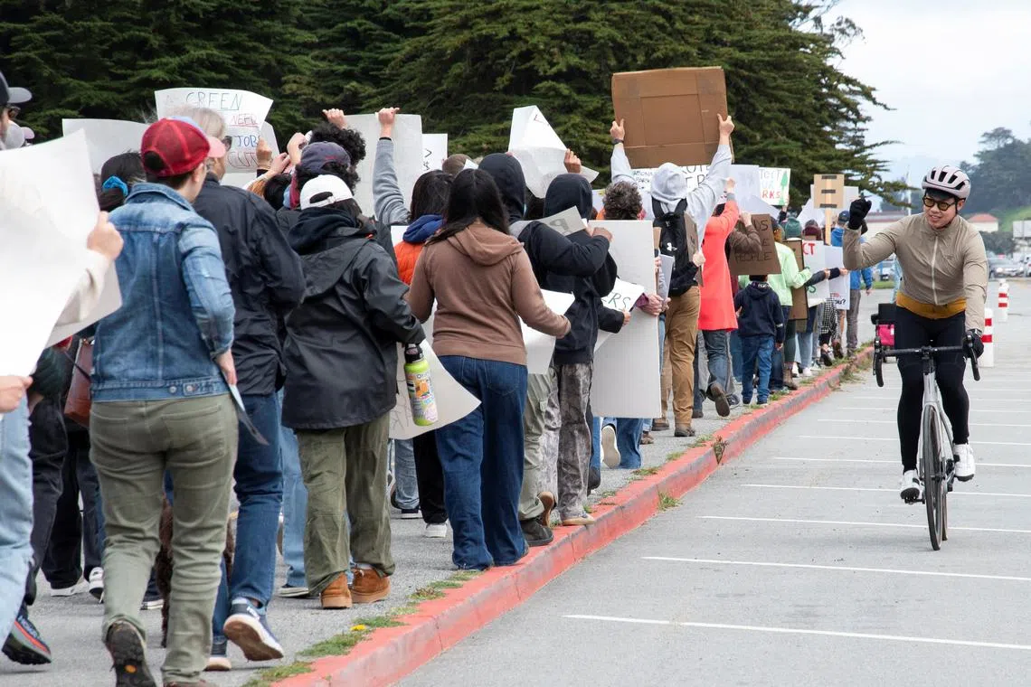 A cyclist shows support to demonstrators participating in a protest against the mass firings of federal employees in a campaign by President Donald Trump and his adviser Elon Musk to radically cut back the US bureaucracy, in San Francisco on March 1.