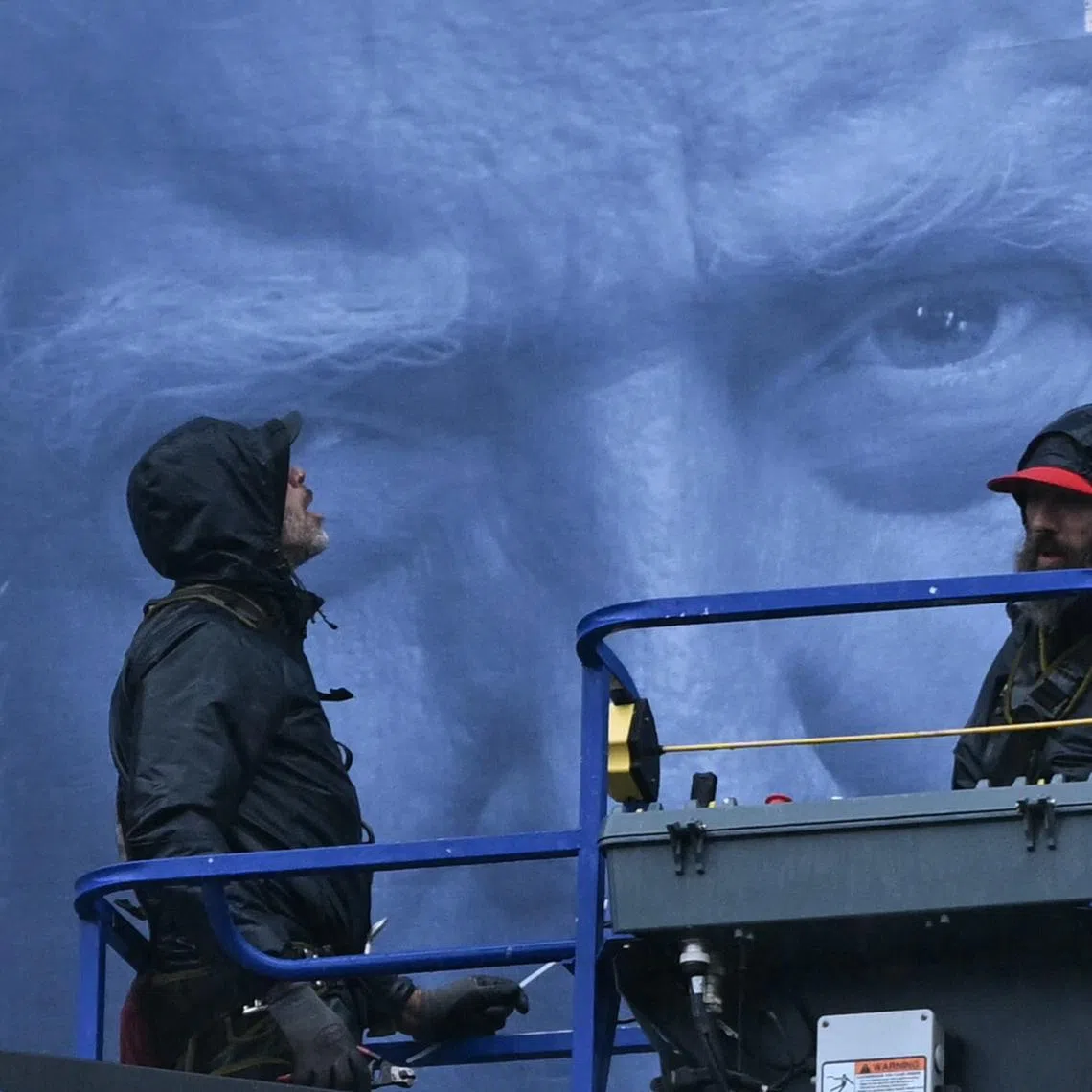 Workers on an aerial lift installing a new banner featuring US President Donald Trump on the façade of the US Department of Justice headquarters, in Washington, DC, on Feb 19, 2026.