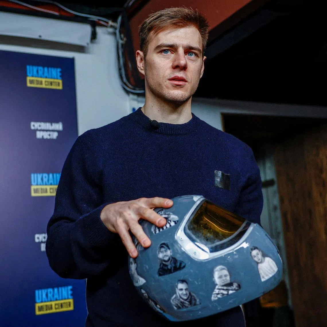 Vladyslav Heraskevych, a Ukrainian skeleton racer, holds his helmet with images depicting athletes killed since the start of Russia's invasion of Ukraine, during a press conference after he was disqualified from the Milano Cortina 2026 Winter Olympic Games for wearing it, in Kyiv, Ukraine, February 19, 2026. REUTERS/Alina Smutko