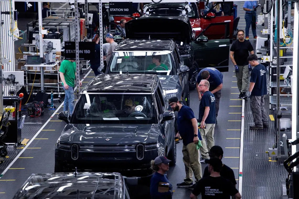 FILE PHOTO: Workers assemble second-generation R1 vehicles at electric auto maker Rivian's manufacturing facility in Normal, Illinois, U.S. June 21, 2024.  REUTERS/Joel Angel Juarez/File Photo