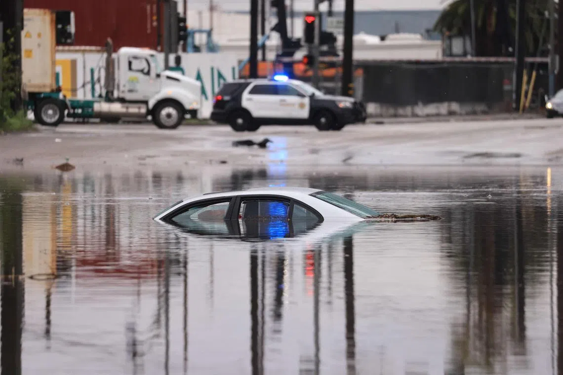 A car sits partially submerged on a flooded road during a rain storm in Long Beach, California, on Feb 1. The US West Coast is getting drenched as the first of two powerful storm systems moves in. 