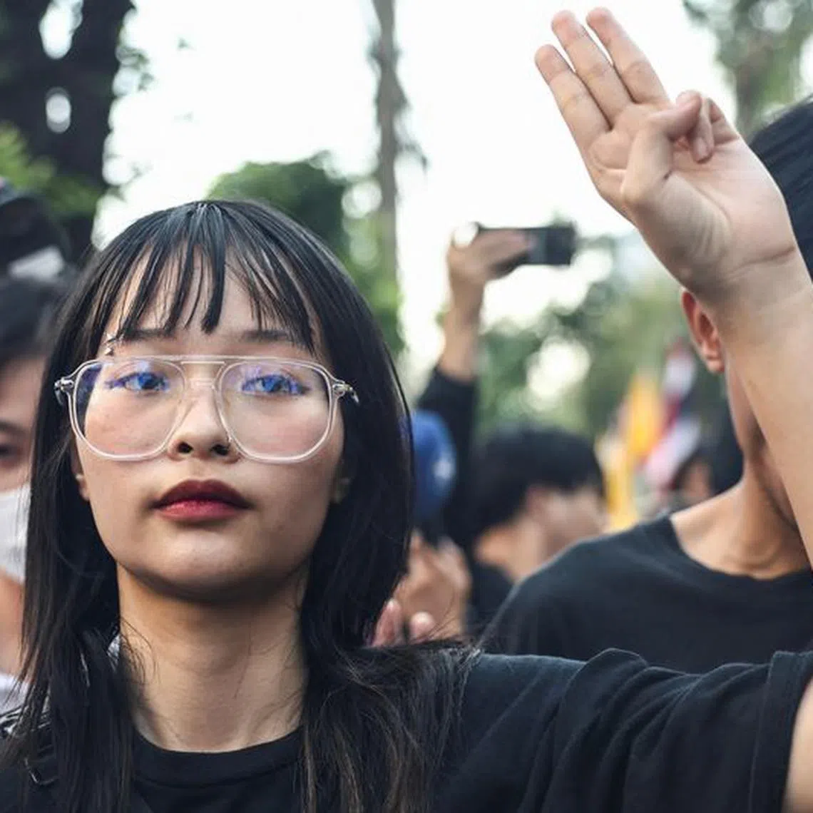 Thai monarchy reform activist Tantawan \"Tawan\" Tuatulanon shows a three-finger salute as she is arrested for sedition and related charges outside a criminal court in Bangkok, Thailand, February 13, 2024. REUTERS/Chalinee Thirasupa