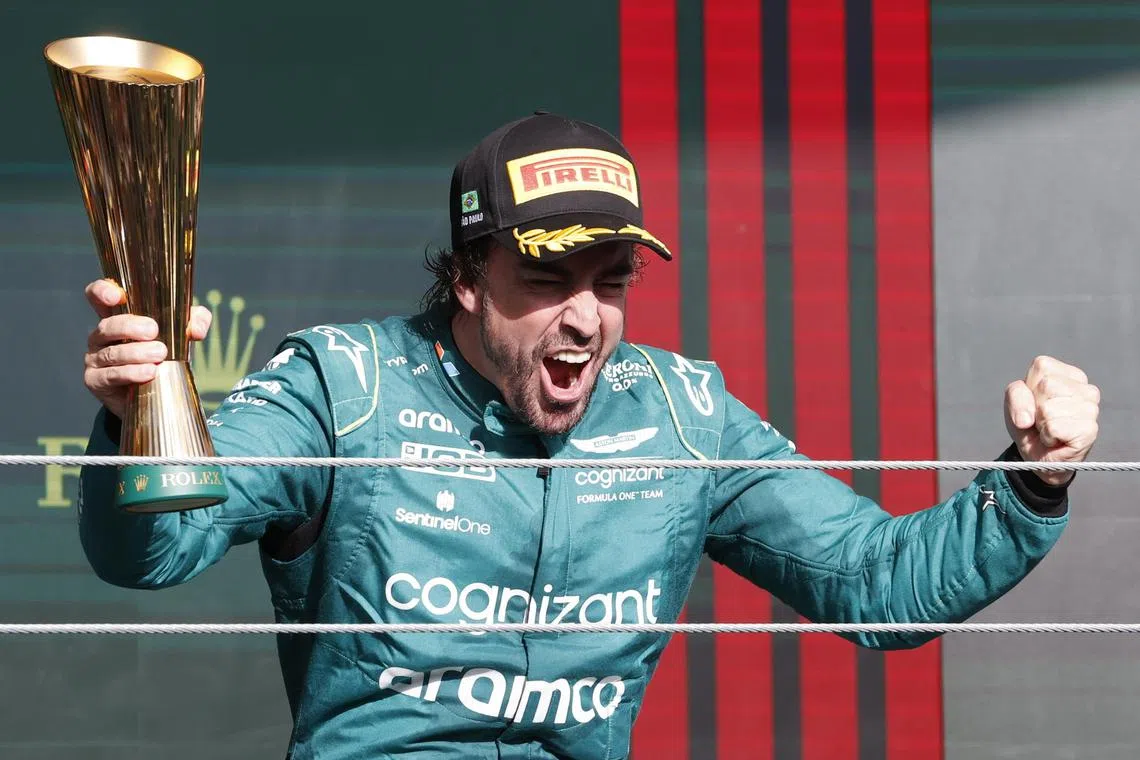 Fernando Alonso of Aston Martin celebrating on the podium after the Brazilian Grand Prix, where he finished third.