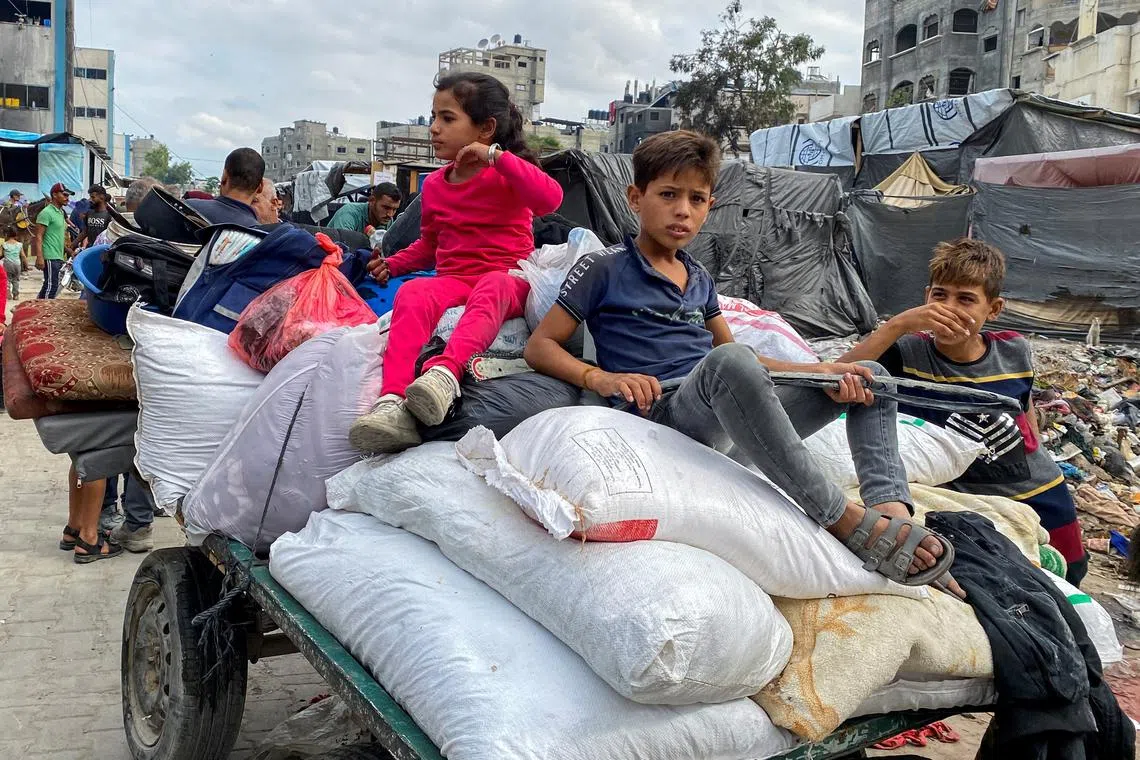 FILE PHOTO: Displaced Palestinian children ride atop an animal-drawn cart loaded with belongings as they flee areas in northern Gaza Strip following an Israeli evacuation order, amid the Israel-Hamas conflict, in Jabalia, October 6, 2024. REUTERS/Hussam Al-Zaanin/File Photo