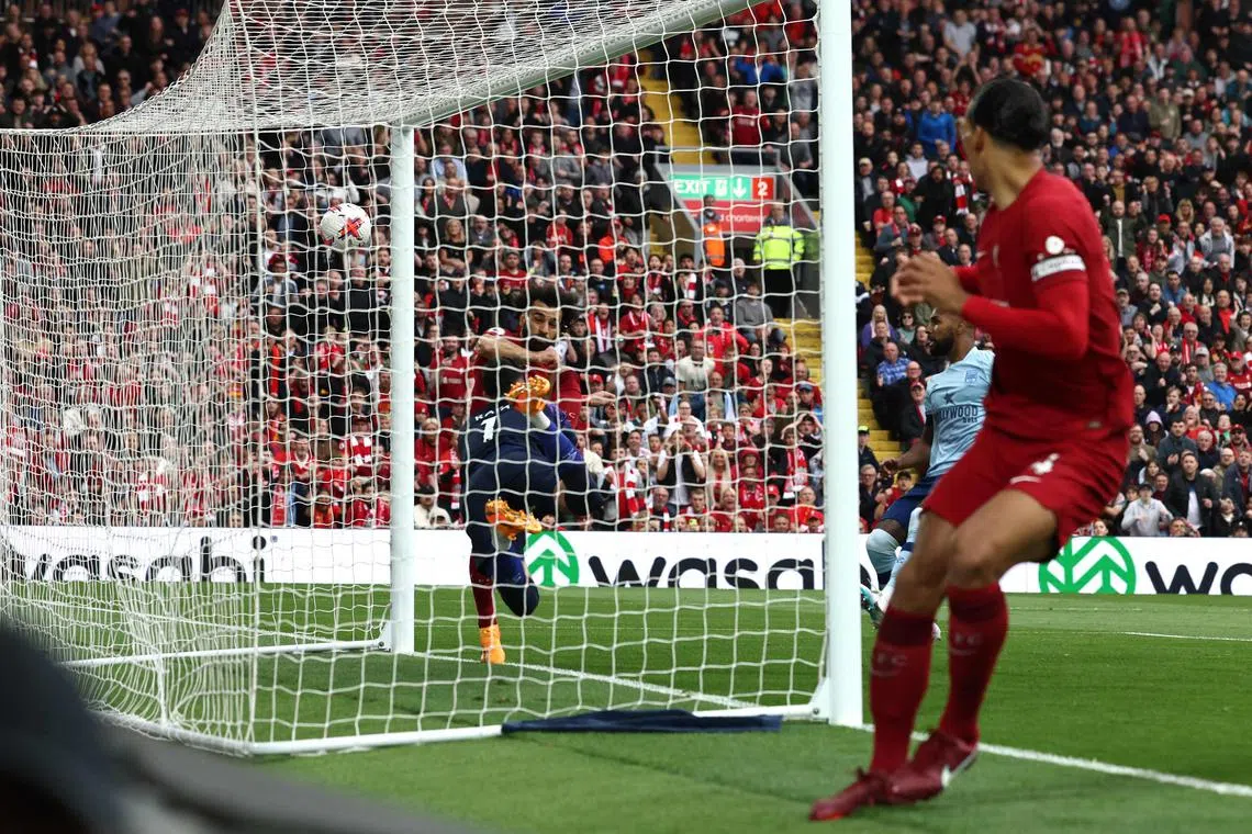 Liverpool's Egyptian striker Mohamed Salah (left) kicks to score his team's first goal.