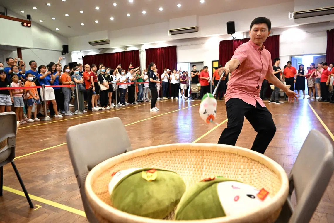 Mr Chee Hong Tat, Senior Minister of State, Ministry of Finance & Ministry of Transport, tries his hand at the Dumplings Dash game at the 2023 Duan Wu Carnival held by the Singapore Federation of Chinese Clan Associations and Singapore Chinese Culture Centre on June 17, 2023.
