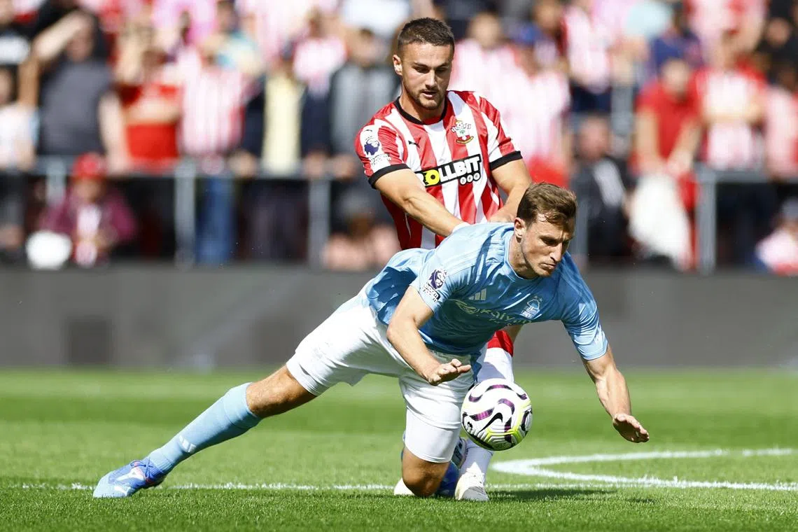 Soccer Football - Premier League - Southampton v Nottingham Forest - St Mary's Stadium, Southampton, Britain - August 24, 2024  Southampton's Taylor Harwood-Bellis in action with Nottingham Forest's Chris Wood Action Images via Reuters/Peter Cziborra