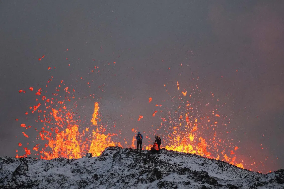 epa11037612 A team of scientists works on the ridge of a volcanic fissure as lava spews during a volcanic eruption, near the town of Grindavik, in the Reykjanes peninsula, southwestern Iceland, 19 December 2023. The Icelandic Meteorological Office (IMO) announced the start of a volcanic fissure eruption near the Sundhnuka crater, north-east of Grindavik, on the night of 18 December, following weeks of intense earthquake activity in the area. The power and seismic activity of the eruption have decreased over time, IMO reported on 19 December, adding that since the eruption began, about 320 earthquakes have been recorded. EPA-EFE/ANTON BRINK