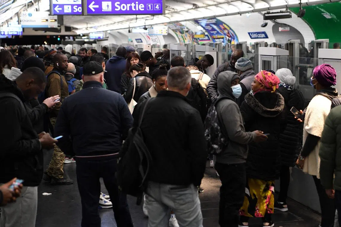 TOPSHOT - Commuters wait on a platform at Saint-Lazare Metro station in Paris on November 10, 2022, during a strike. - Seven lines of the Paris metro will be completely closed and seven others only open during rush hour due to a strike on November 10, 2022 to demand wage increases and improved working conditions, the RATP said on November 8, 2022. European workers squeezed by the soaring cost of living went on strike in Belgium and Greece on November 9, 2022, with stoppages threatening to paralyse parts of Britain, France and Spain in coming days. (Photo by Bertrand GUAY / AFP)