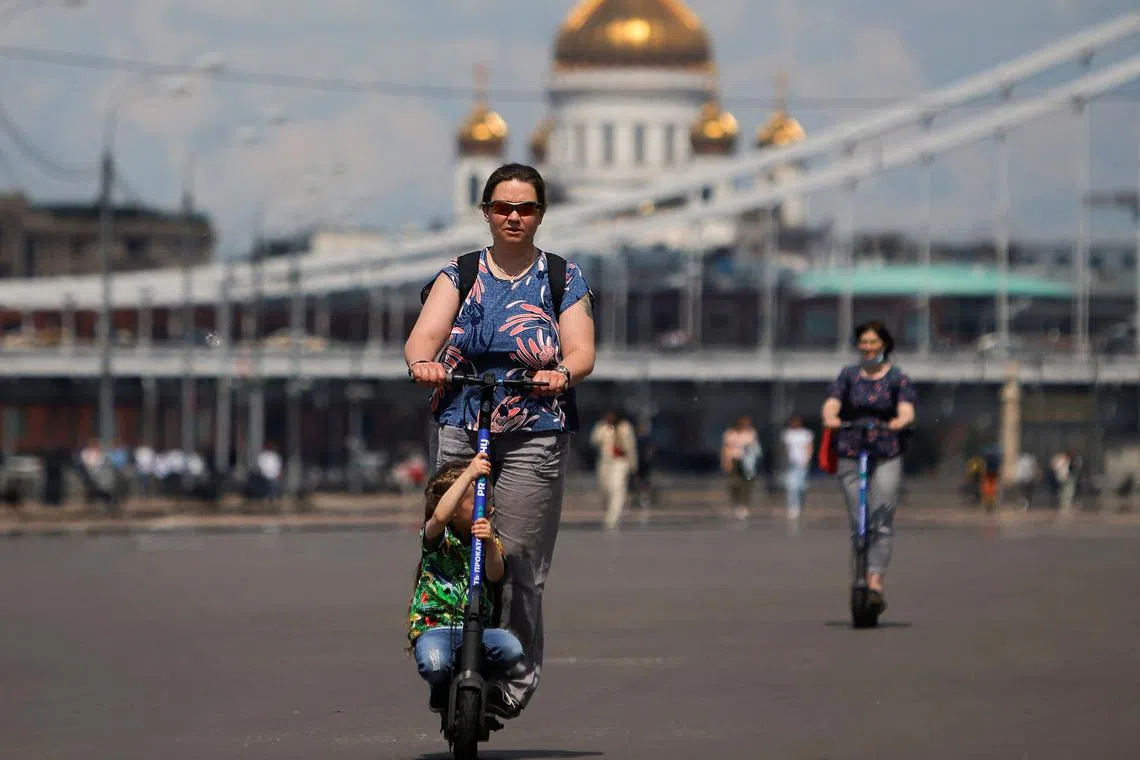 FILE PHOTO: People ride electric scooters in Moscow, Russia June 8, 2021.  REUTERS/Maxim Shemetov/File Photo
