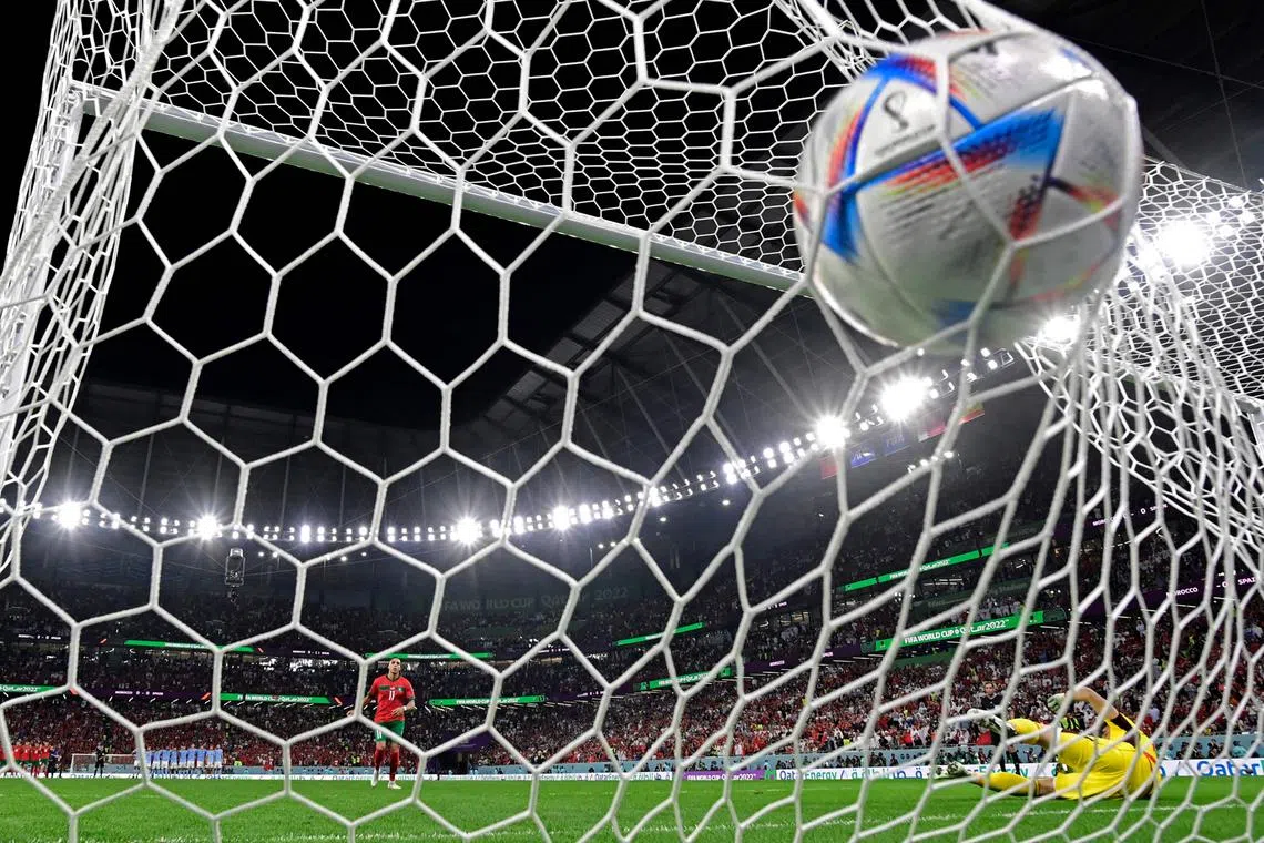 Spain's goalkeeper #23 Unai Simon concedes a goal by Morocco's midfielder #11 Abdelhamid Sabiri (L) during penalty shoot-out in the Qatar 2022 World Cup round of 16 football match between Morocco and Spain at the Education City Stadium in Al-Rayyan, west of Doha on Dec 6, 2022. 
