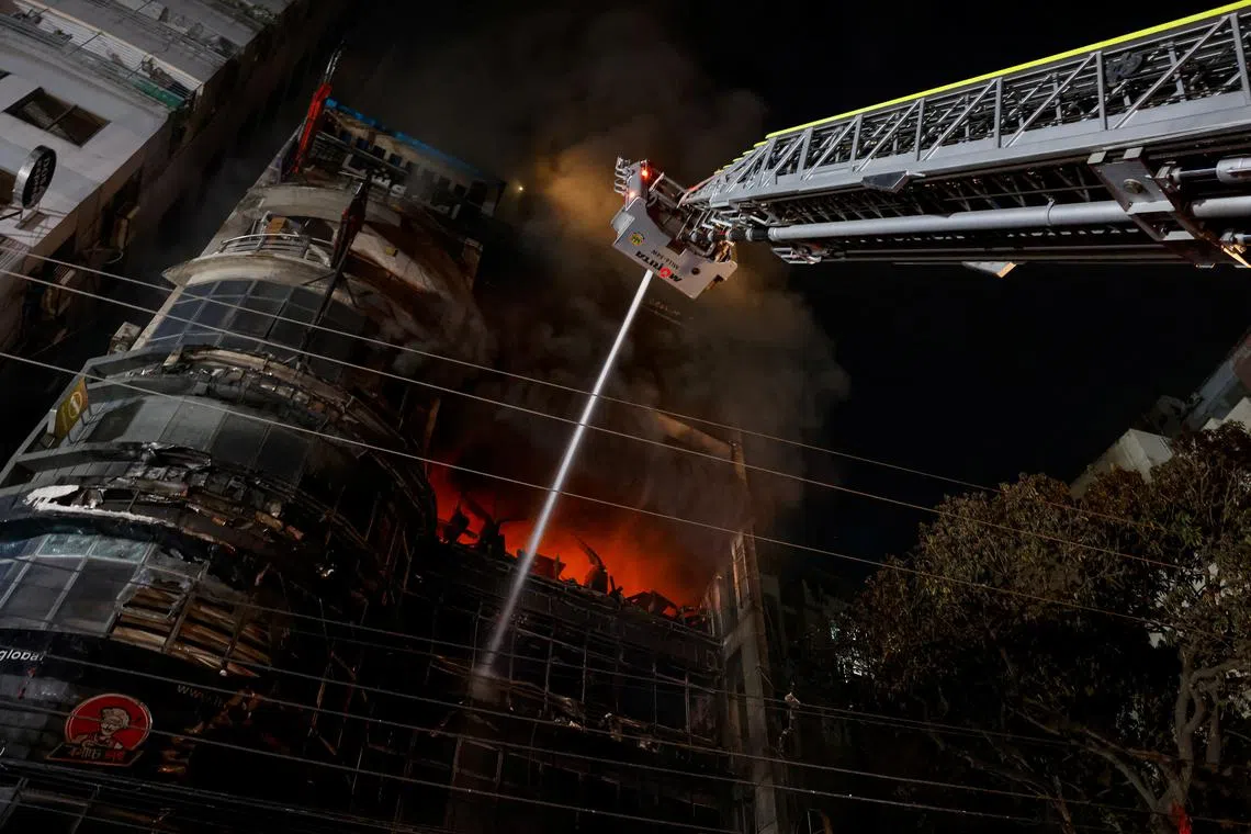 FILE PHOTO: Firefighters spray water to douse a fire that broke out in a multi storey building in Dhaka, Bangladesh, February 29, 2024. REUTERS/Mohammad Ponir Hossain/File Photo