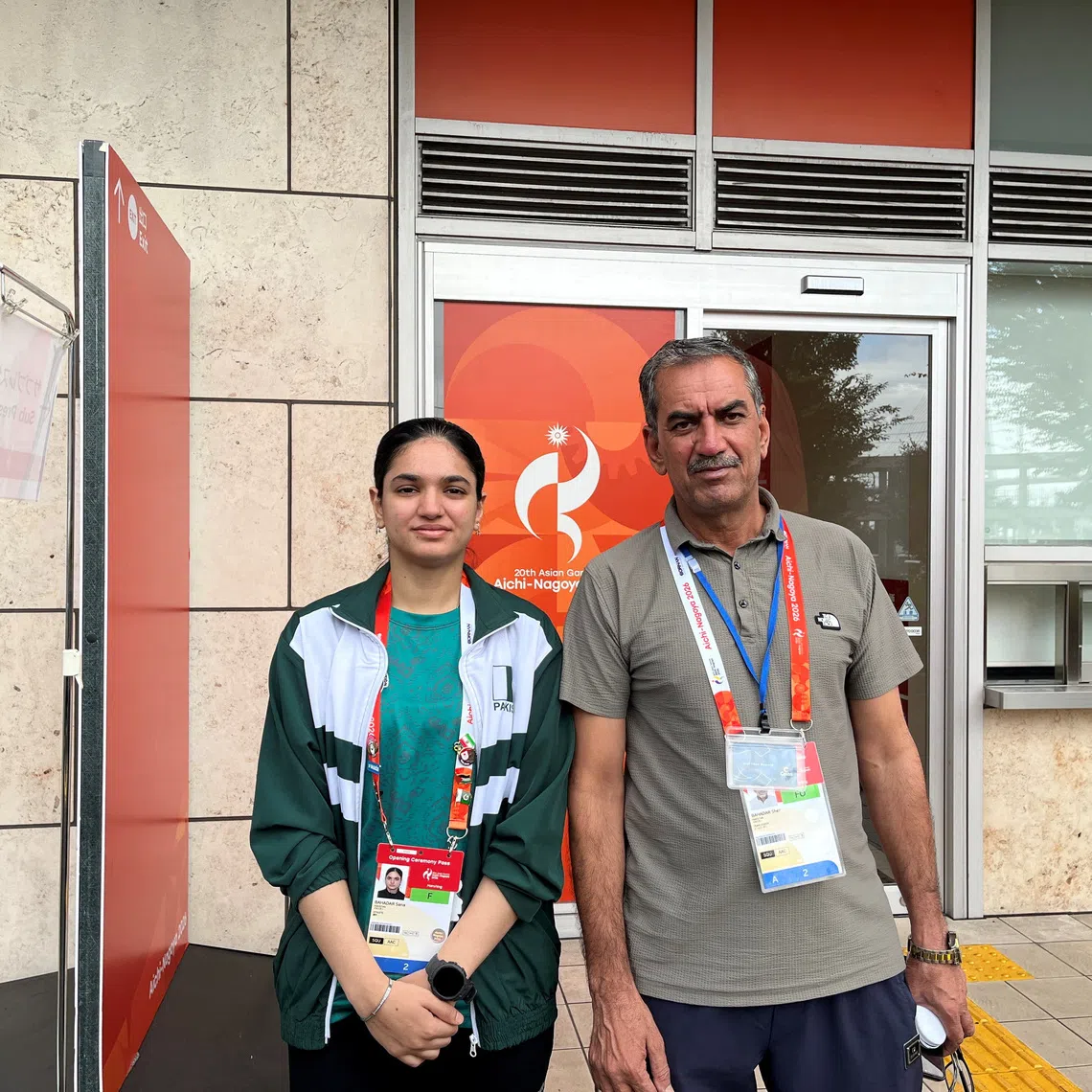 Asian Games - Aichi-Nagoya 2026 - Squash - Nagoya Kinjo Futo Arena, Nagoya, Japan - September 23, 2026 Pakistan squash player Sana Bahadar and her father Sher Bahadar pose for a picture outside the Nagoya Kinjo-Futo Arena REUTERS/Amlan Chakraborty