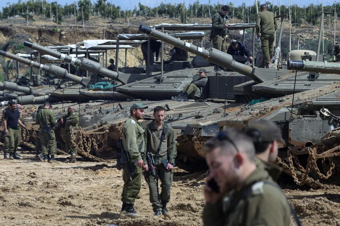 Israeli soldiers stand next to tanks near the Israeli side of the border with Lebanon, amid escalation between Iran-backed Hezbollah and Israel and the U.S.-Israeli conflict with Iran, in northern Israel, March 23, 2026.