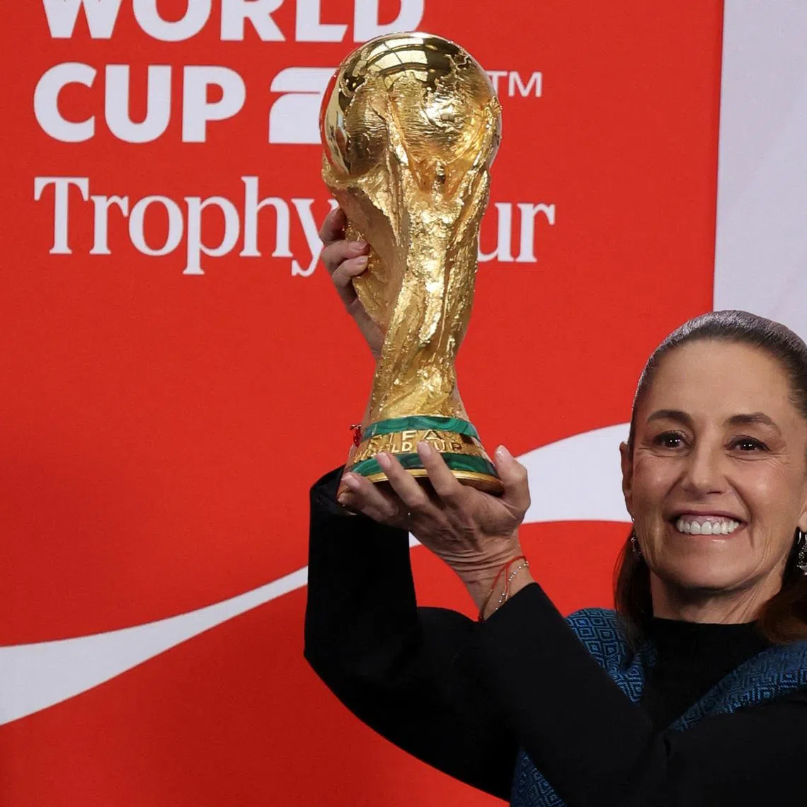 Mexico's President Claudia Sheinbaum lifts the FIFA World Cup trophy during her morning press conference at the National Palace, in Mexico City, Mexico, March 3, 2026. REUTERS/Stringer