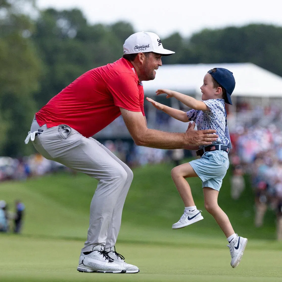 Keegan Bradley celebrating with his son Cooper after winning the Travelers Championship golf tournament at TPC River Highlands in Cromwell, Connecticut, on June 22, 2025.