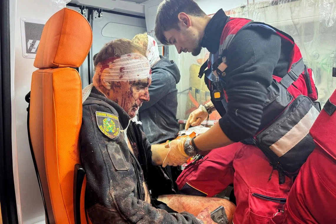 A medical worker treating a wounded police officer in an ambulance at the site of a Russian missile strike on the Ukrainian city of Kharkiv, on Nov 1.