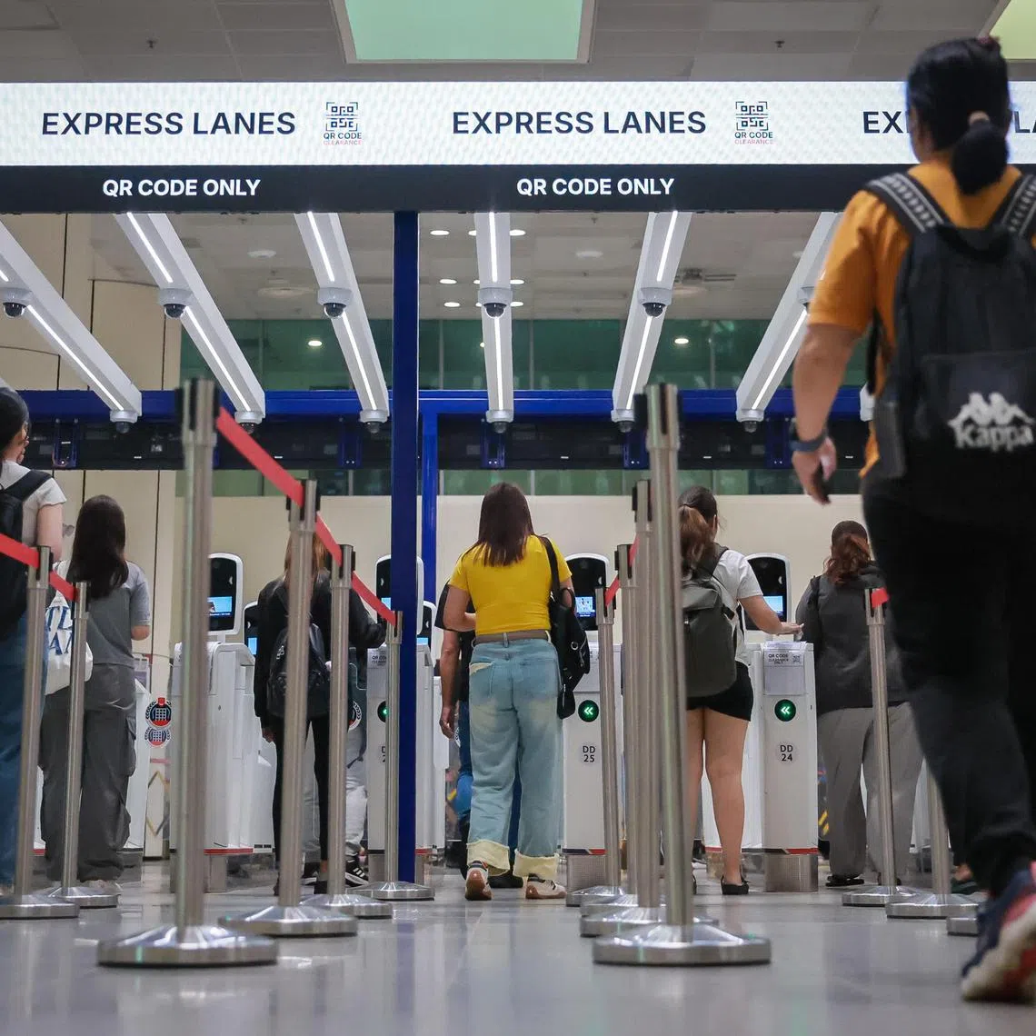 Travellers using QR code clearance at the automated lanes of the bus hall at Woodlands Checkpoint on March 27, 2025.