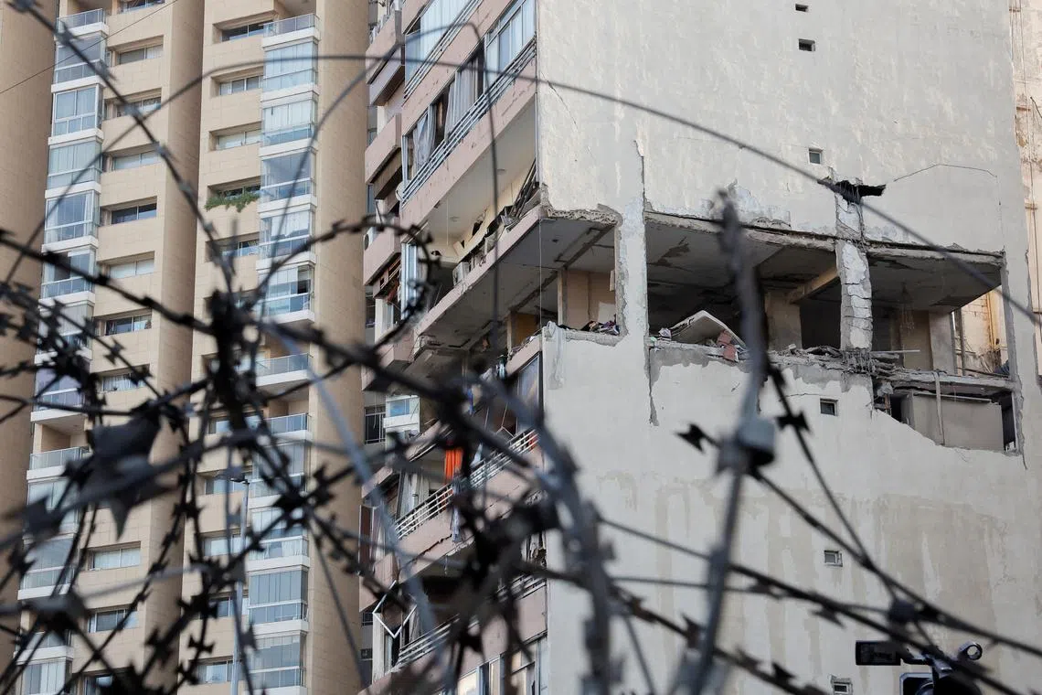 A building damaged in an Israeli strike is seen through a razor wire fence, amid ongoing cross-border hostilities between Hezbollah and Israeli forces, in Kola, central Beirut, Lebanon September 30, 2024. REUTERS/Louisa Gouliamaki