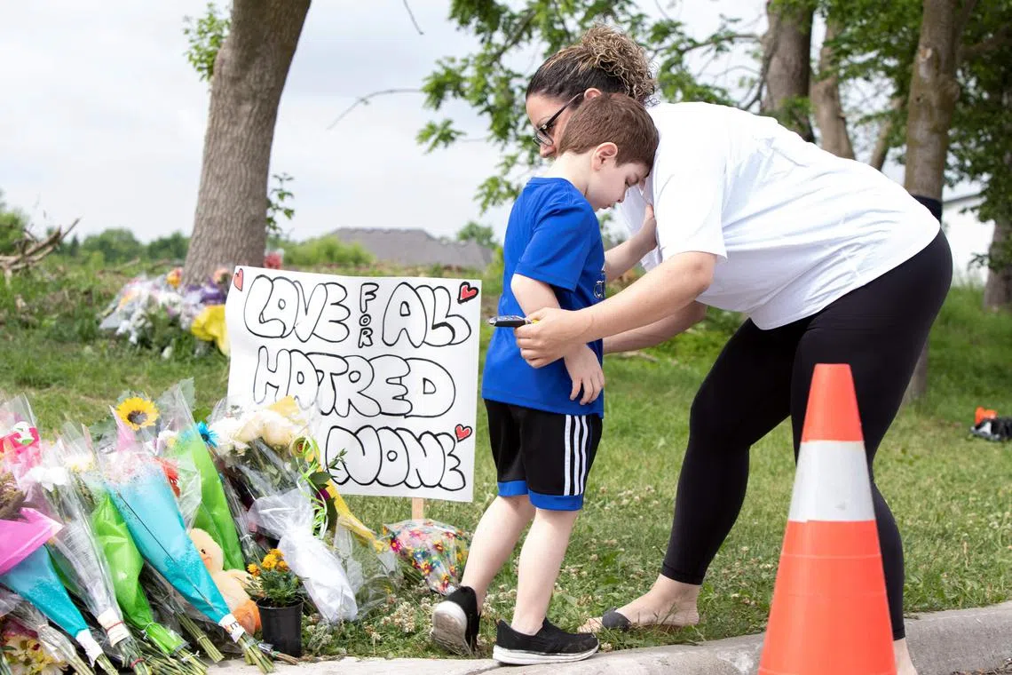 (FILES) Families pay their respects on June 8, 2021, at a makeshift memorial near the site where a man driving a pickup truck struck and killed four members of a Muslim family in London, Ontario, Canada. Nathaniel Veltman was arrested shortly after the June 6 attack, has been charged with four counts of first-degree murder and one count of attempted murder. Veltman's trial started on September 6, 2023 in Windsor, south of Ontario Province. (Photo by Nicole OSBORNE / AFP)
