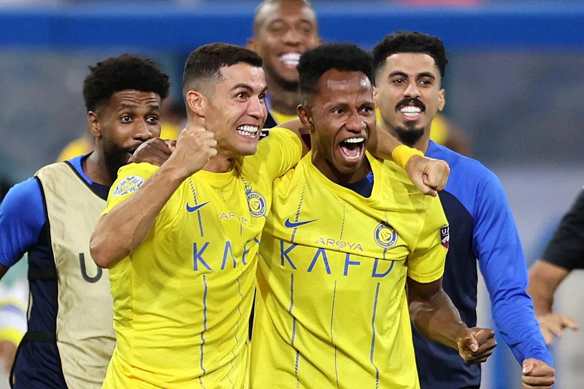 Al Nassr's Cristiano Ronaldo celebrates with teammates after winning the Arab Club Champions Cup final.