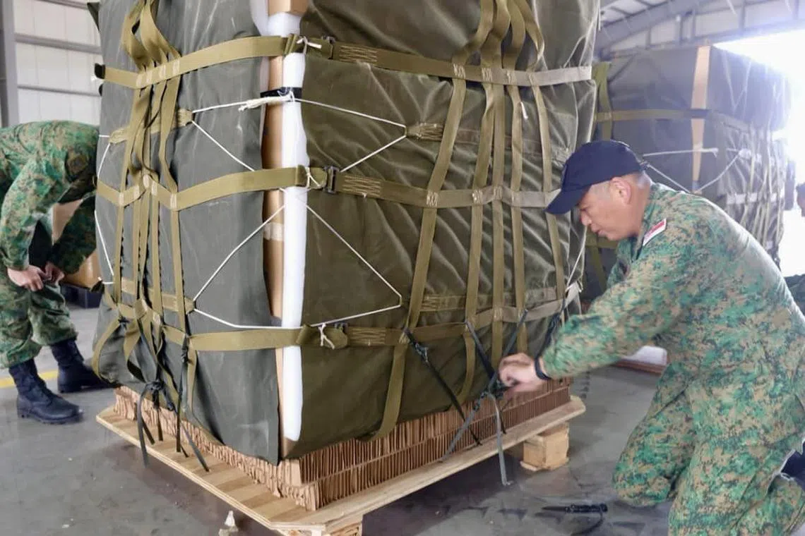 Aerial cargo riggers from The Singapore Army securing the humanitarian supplies for the airdrop mission.