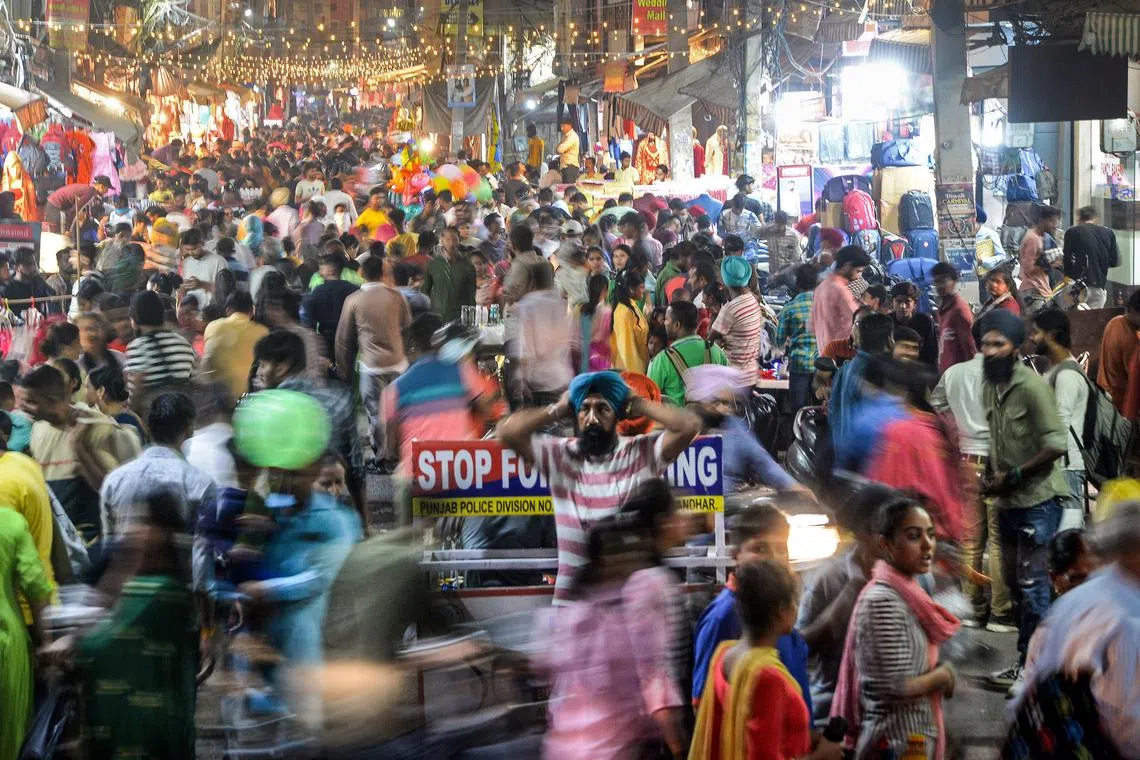 A large, packed crowd at a market in Jalandhar, India.The global population will breach the symbolic level of 8 billion on Nov 15, according to the UN.