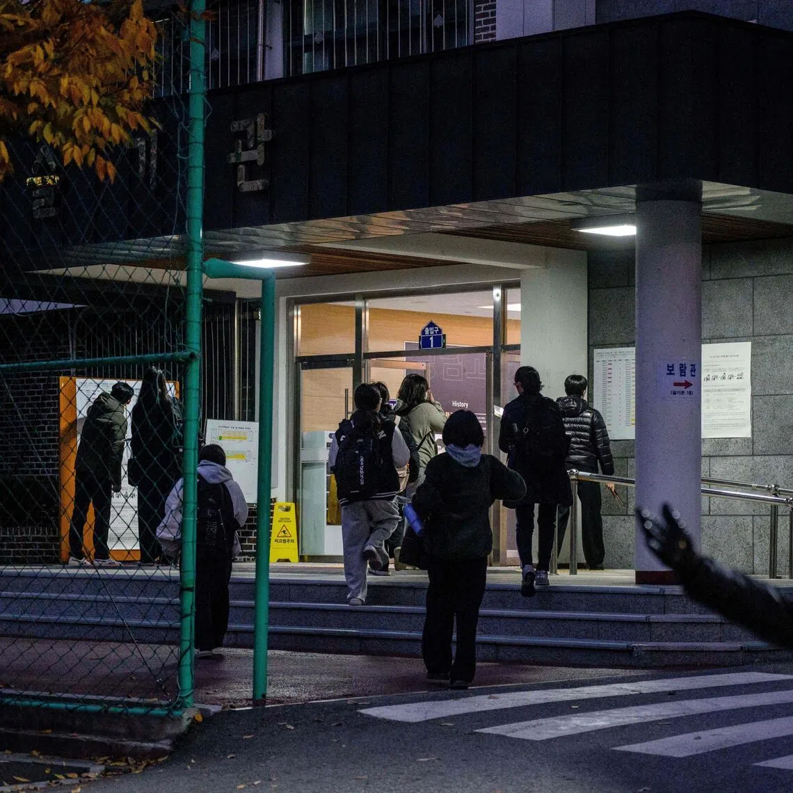Students arrive (back) for the annual college entrance exam, known locally as Suneung, at the Gwangnam High School, in Seoul, on November 13, 2025. (Photo by ANTHONY WALLACE / AFP)
