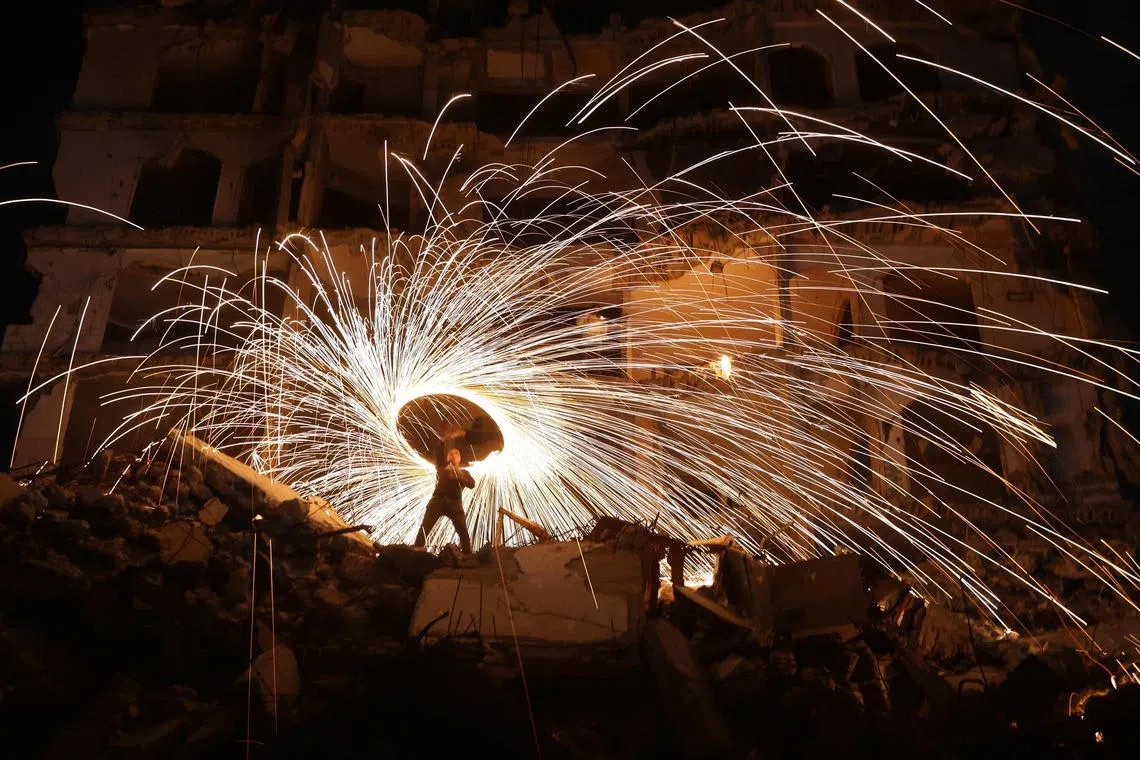 A displaced Palestinian playing with fireworks after breaking his fast, outside a damaged building at the Jabalia refugee camp in the northern Gaza Strip, during the Muslim holy fasting month of Ramadan, on Feb 23, 2026. 