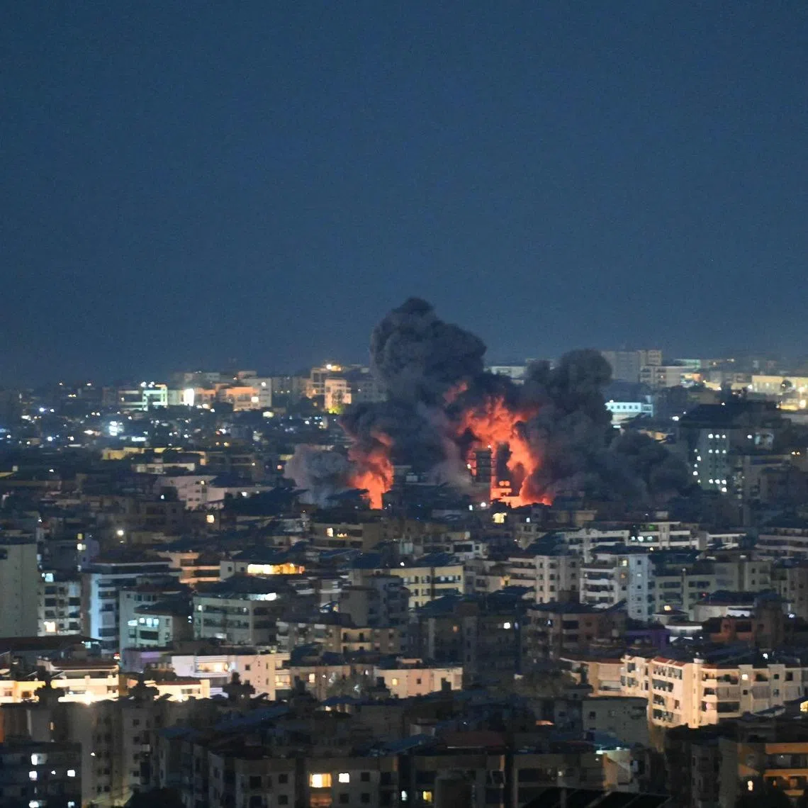 Fire blazes and black smoke rises from the site of an Israeli airstrike that targeted the office of the Hezbollah affiliated Al-Manar TV station in Beirut’s southern suburb of Haret Hreik on March 3.