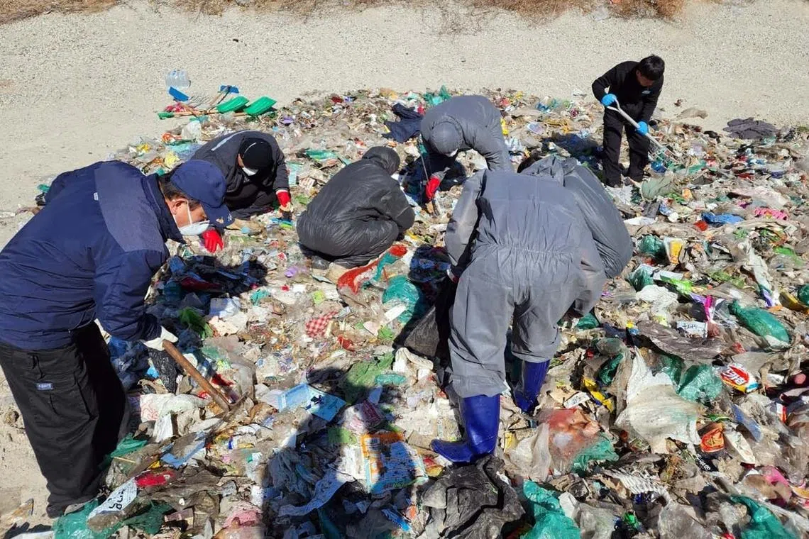 Civil servants from the local sanitation department search through the garbage at an area central waste processing station to help a woman find 26 million won she had accidentally thrown away in Sejong City, on Feb 24. 