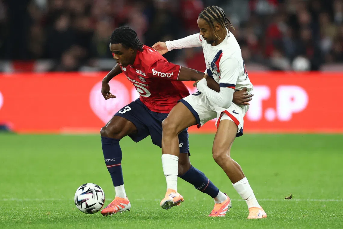 Soccer Football - Ligue 1 - Lille v Paris St Germain - Decathlon Arena Stade Pierre-Mauroy, Villeneuve-d'Ascq, France - October 5, 2025 Lille's Nathan Ngoy in action with Paris St Germain's Bradley Barcola REUTERS/Gonzalo Fuentes