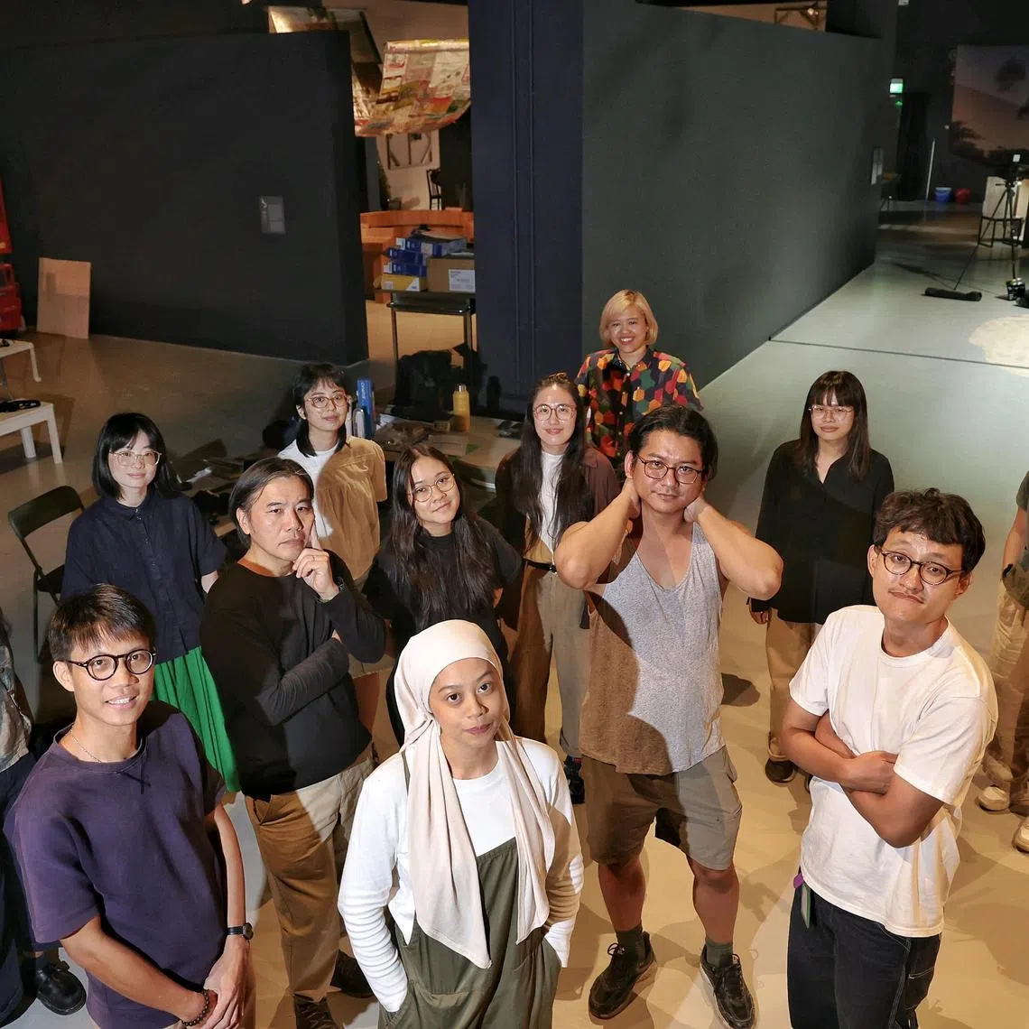 (Front row from left) Artist Chu Hao Pei, artist Lee Pheng Guan, artist NEO_ARTEFACTS, artist Masuri Mazlan, artist Syahrul Anuar, (back row from left) curatorial assistant Angela Pinto, curator Joella Kiu, curatorial assistant for design Siobhan Tang, assistant curator Syaheedah Iskandar, curatorial assistant Seline Teo, curator for design Berny Tan, curatorial assistant Angelica Ong, and curator and manager (Collections) Teng Yen Hui in the space for How to Dream Worlds at Singapore Art Museum on July 18, 2025.
