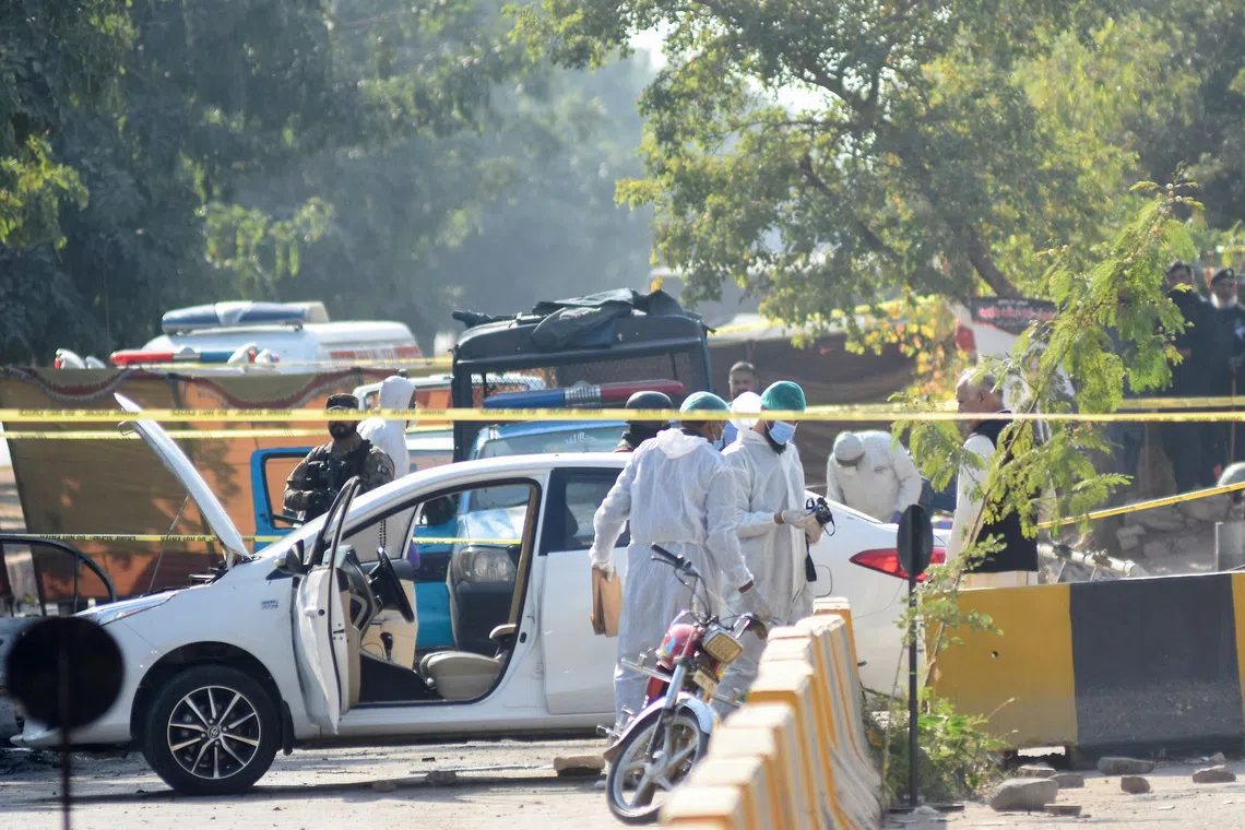 Forensic workers carrying out inspections after a blast outside a court building in Islamabad on Nov 11.
