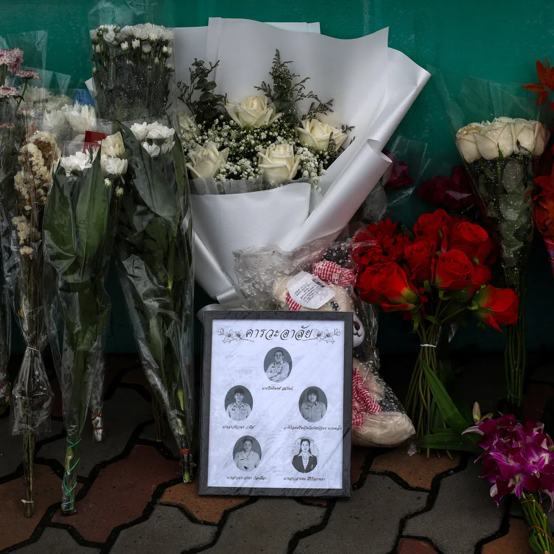 Flowers and pictures of teachers killed are left outside Debsirin Nonthaburi School following a deadly shooting at the school, in Bang Kruai district in Nonthaburi province, on the outskirts of Bangkok, Thailand, Aug 9.