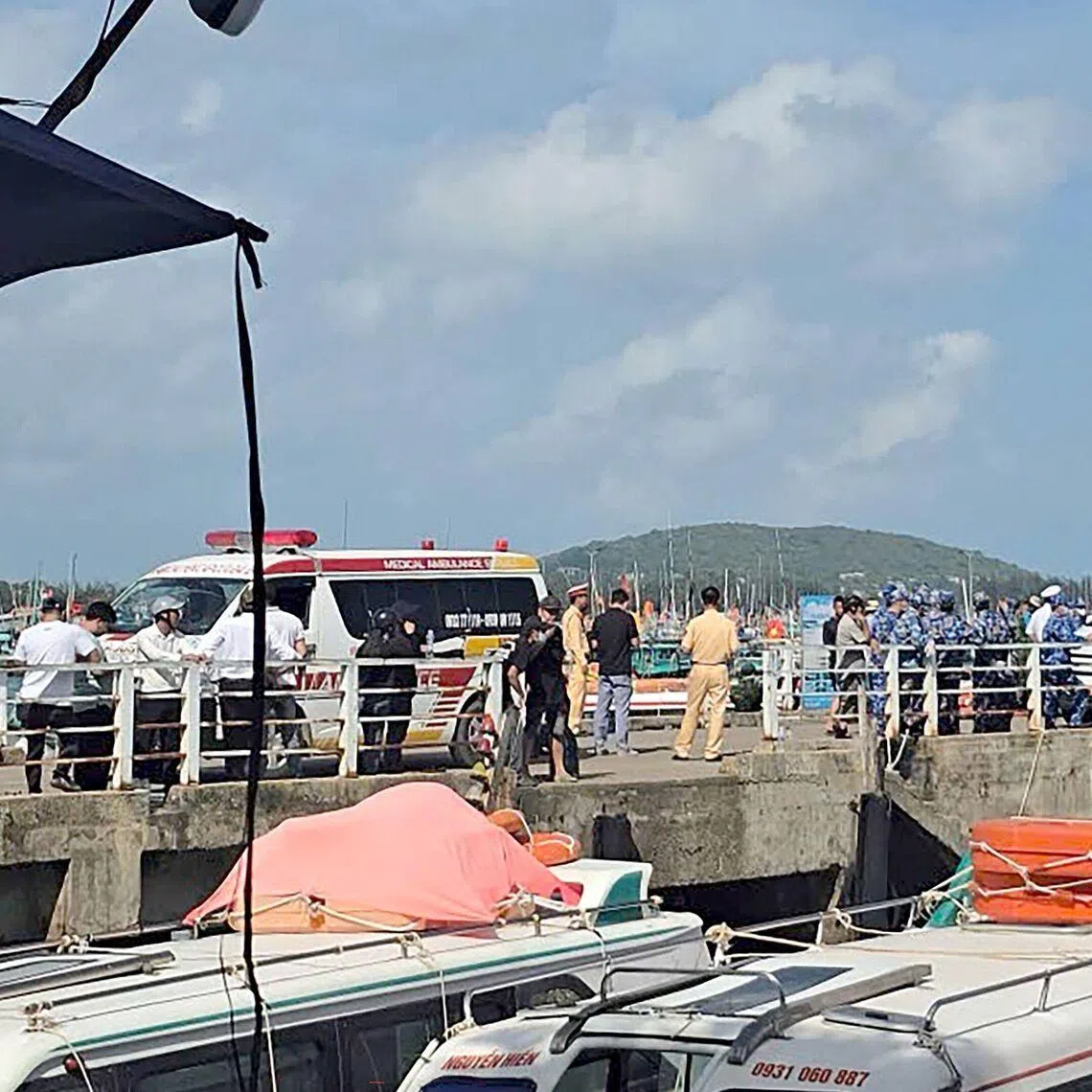 Ambulances line up on a pier to help victims of a boating accident after a tourist vessel capsized off Phu Quoc Island.