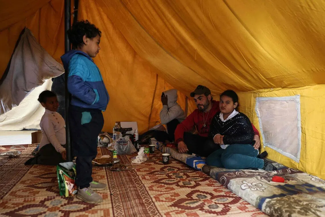 A displaced family sits inside their tent at a sports stadium in Beirut that was converted into a shelter.