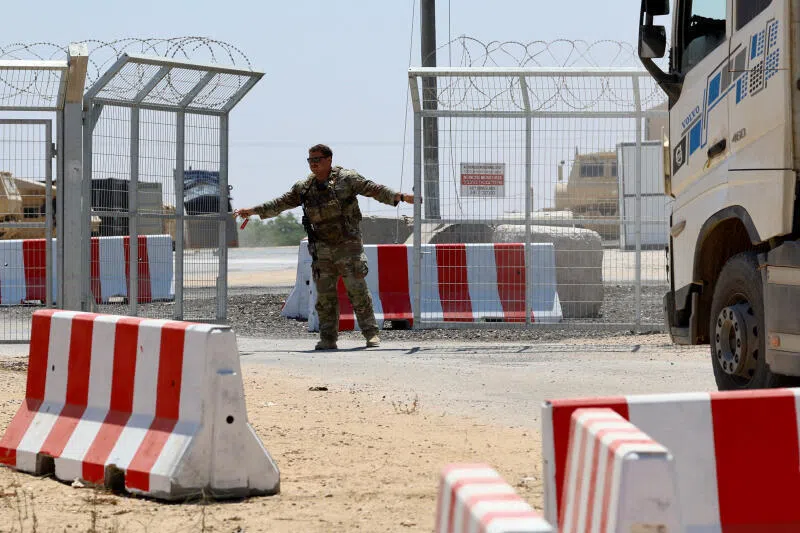 A U.S. soldier opens the entrance to the LSA Endurance, a logistical support and staging facility designed to support the International Stabilization Force (ISF) under the direction of the Board of Peace (BoP), near the Israel-Gaza border in the Kerem Shalom area, southern Israel, August 10, 2026. REUTERS/Amir Cohen