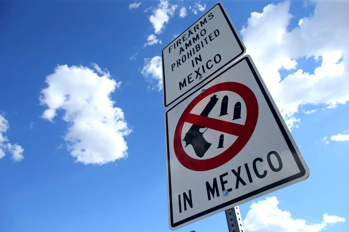 FILE PHOTO: A sign warning drivers that firearms and ammunition are prohibited in Mexico is seen at the U.S.-Mexico border in Nogales, Arizona, United States, October 9, 2016. REUTERS/Mike Blake/File Photo