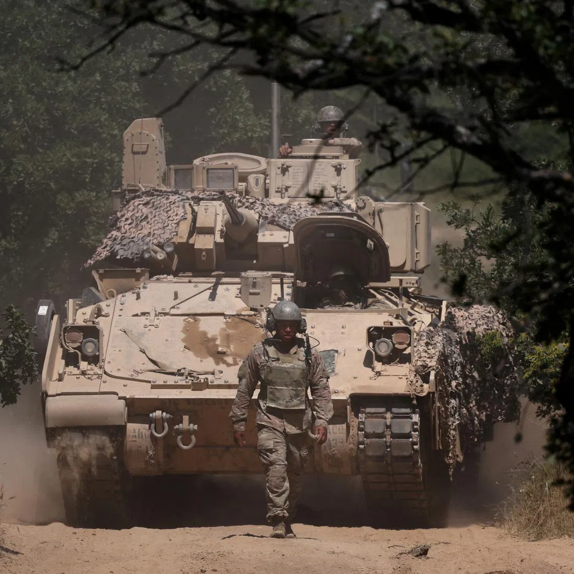 FILE PHOTO: A U.S. soldier walks in front of an armoured vehicle during \"Balkan Sentinel - 25\" military drill, an exercise involving personnel and equipment from the Bulgarian Land Forces and Air Force, formations from the NATO Multinational Battle Group with Italy, and a mechanized platoon from the Romanian Land Forces, in Koren, Bulgaria, June 9, 2025. REUTERS/Stoyan Nenov/File Photo