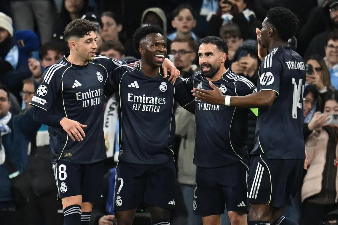 Real Madrid's Vinicius Junior (second from left) celebrates after scoring their second goal in the 93rd minute against City on March 17.