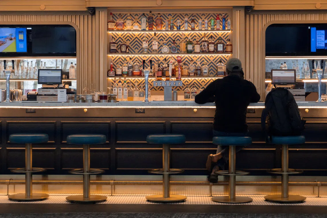 FILE PHOTO: A man sits at a bar in LaGuardia Airport in Queens, New York City, U.S., July 30, 2025. REUTERS/Kylie Cooper/File Photo